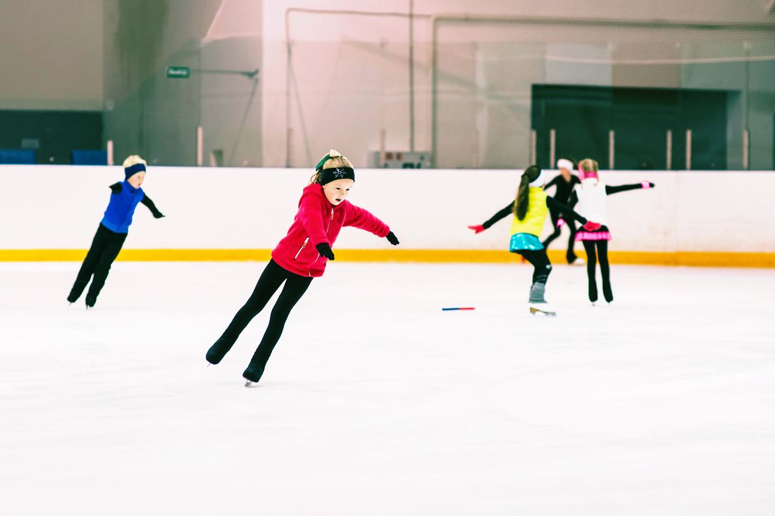 Children skating in ice rink during lesson time